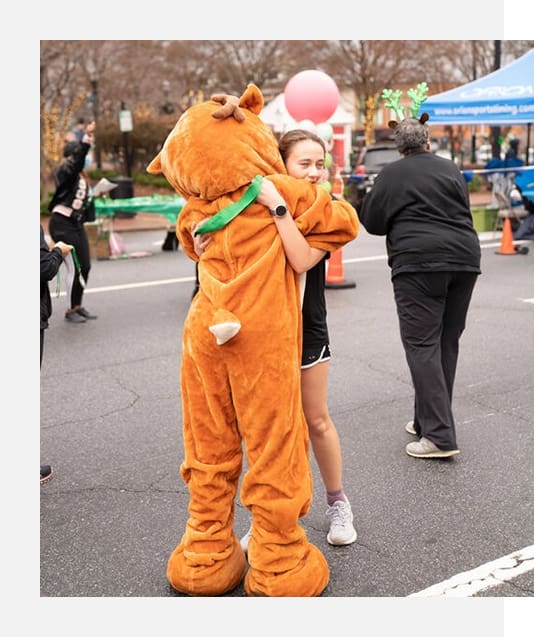 A person in an orange costume is playing with a ball.