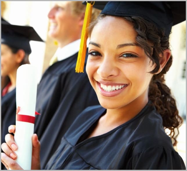 A woman in graduation cap and gown holding a diploma.