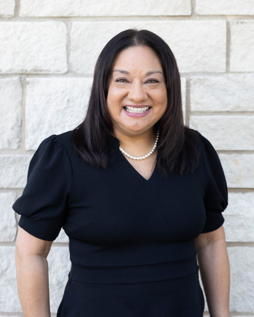 A woman in black shirt smiling for the camera.