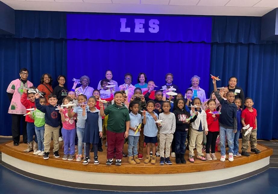 A group of children and adults standing on stage.